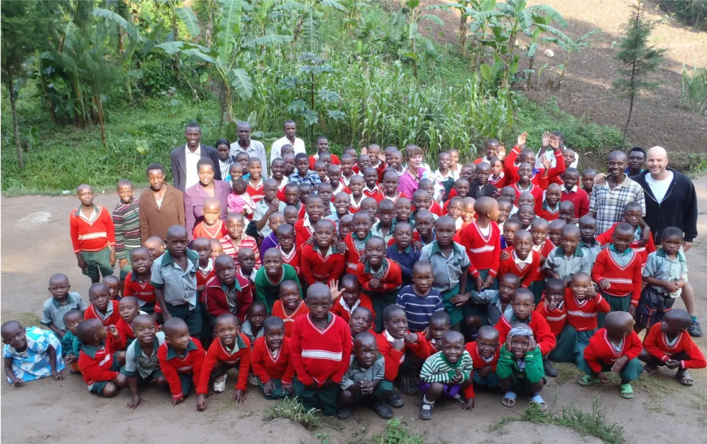 Children and teachers outside a school funded by Peace Pedalers